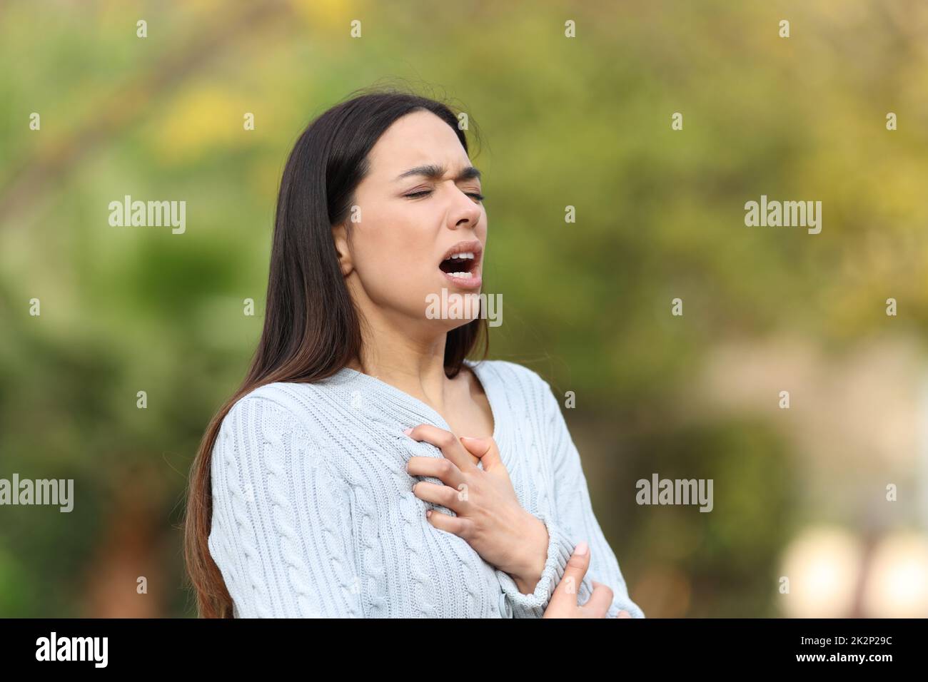 Woman having breath problems in a park Stock Photo