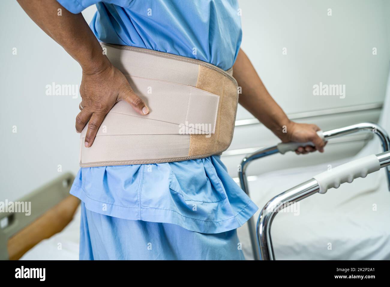Asian lady patient wearing back pain support belt for orthopedic lumbar ...