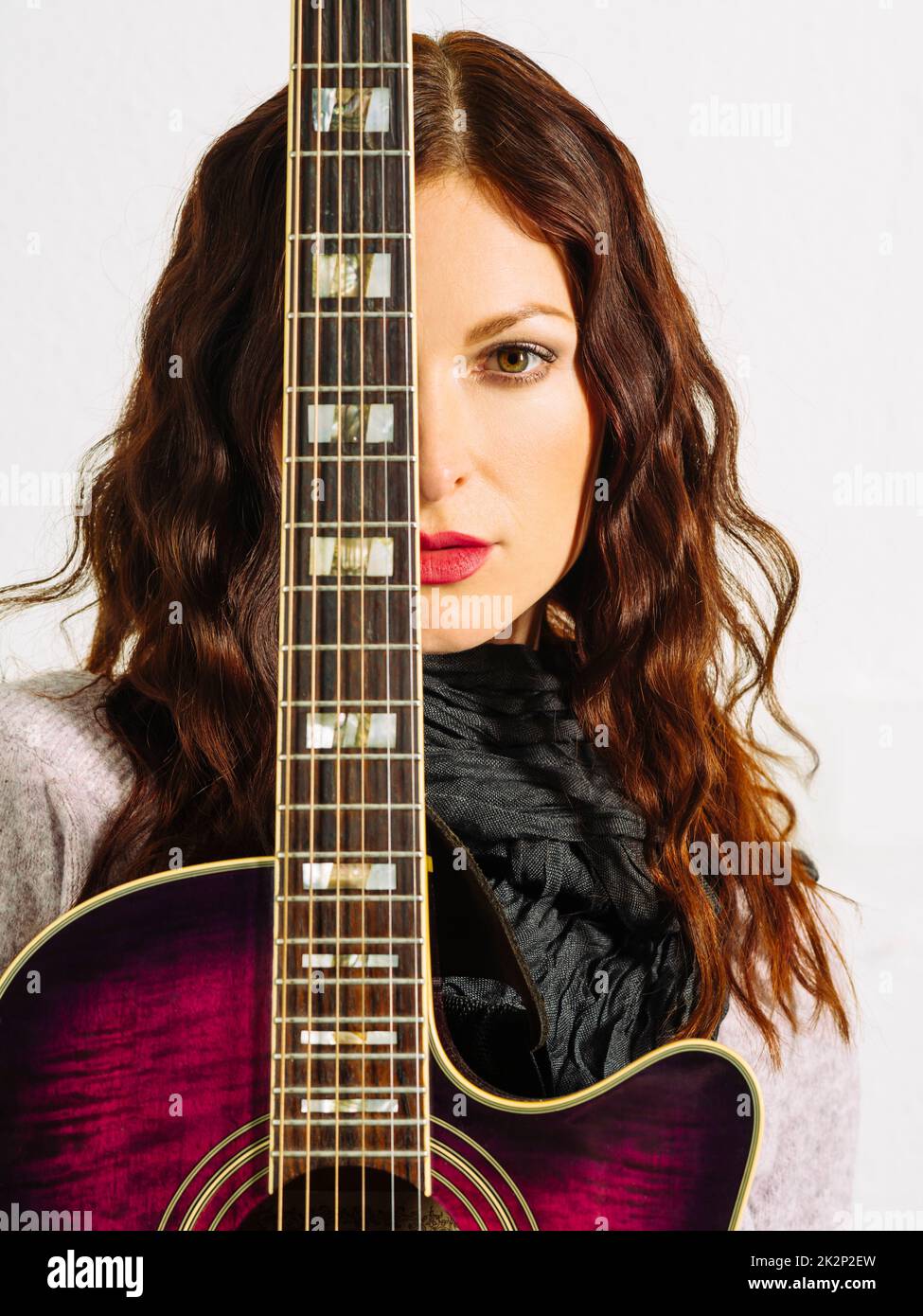 Redhead woman holding acoustic guitar Stock Photo - Alamy