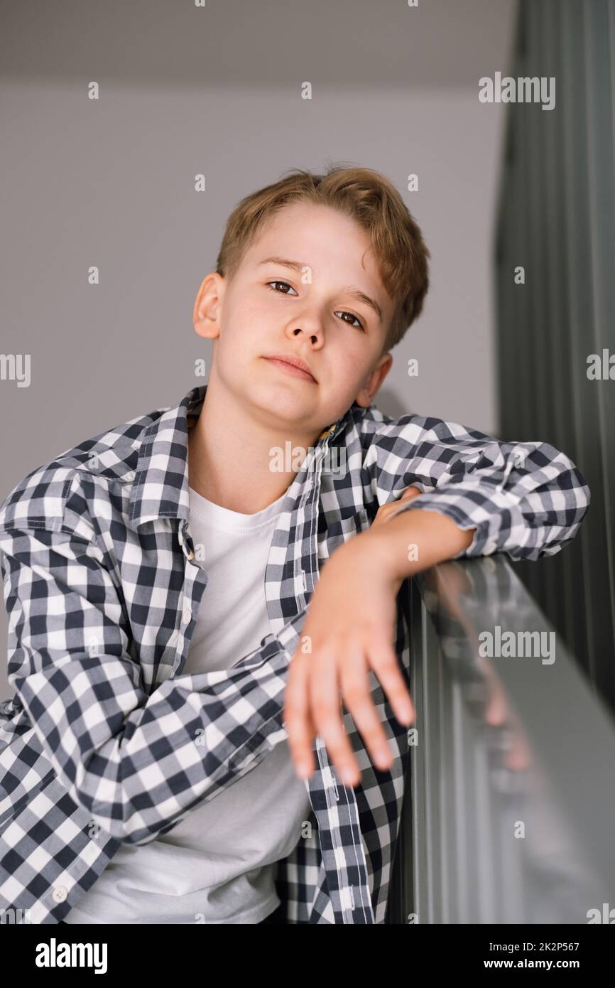 Portrait of a modern teenager looking at the camera. The guy is sitting on the steps Stock Photo