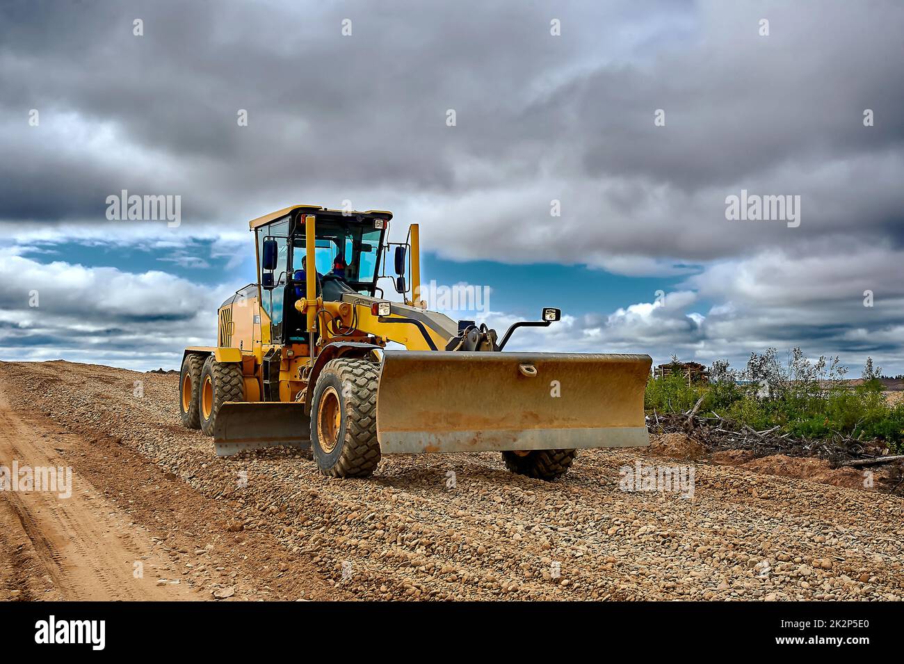 a grader on the construction site levels the rubble Stock Photo