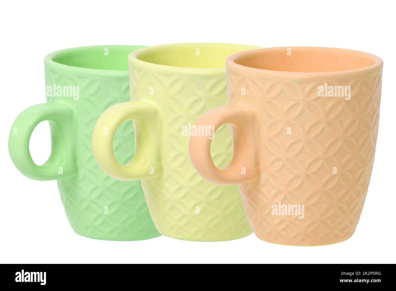 Mug of coffee. Closeup of three empty green, yellow and orange ceramic cups with space for label isolated on a white background. Concept morning coffee. Space. Macro. Stock Photo
