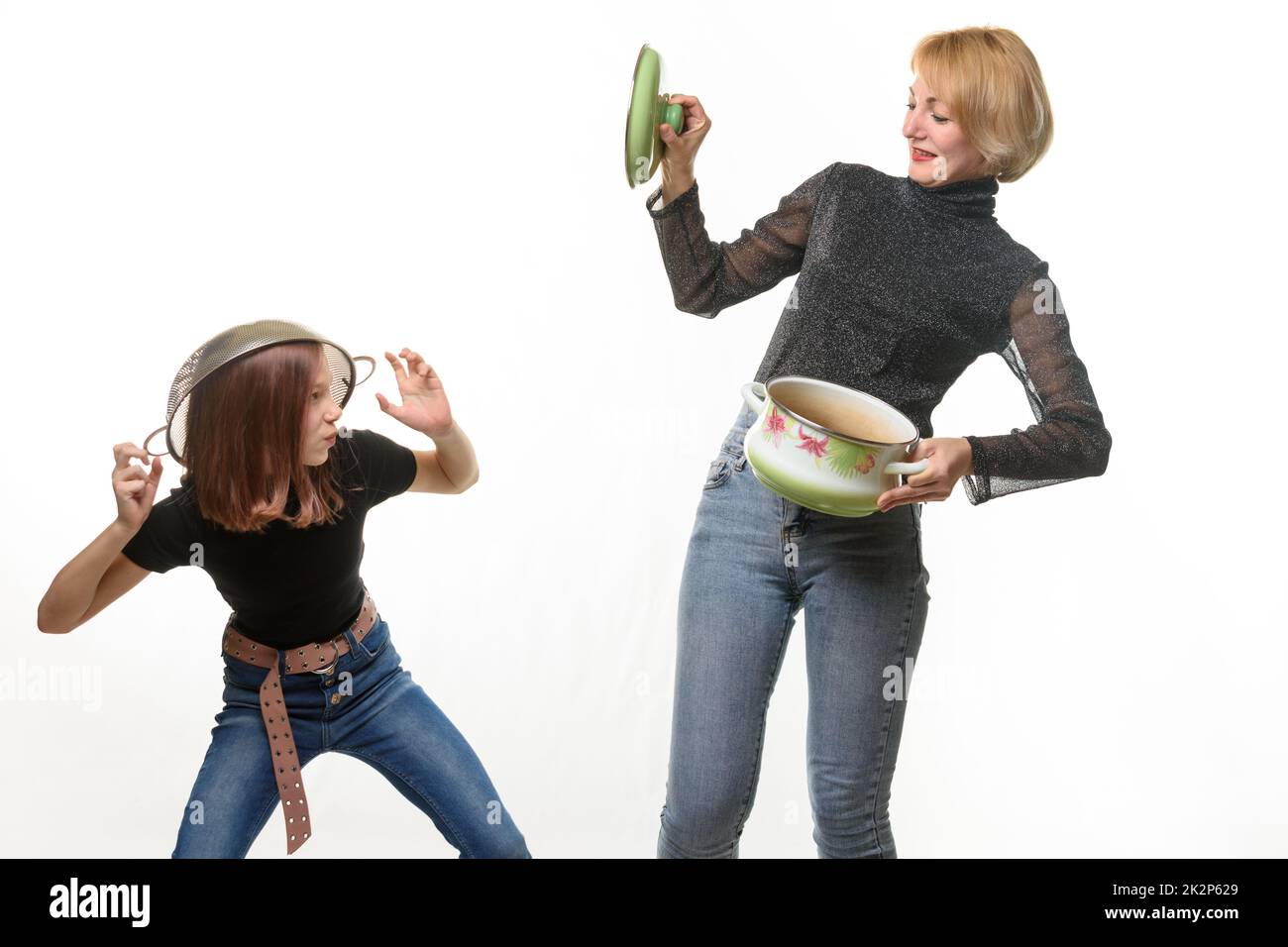 Mom and daughter have fun using kitchen utensils Stock Photo