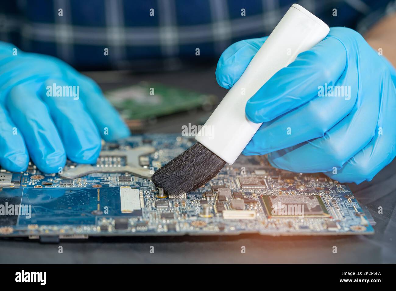 Technician use brush and air blower ball to clean dust in circuit board computer. Repair upgrade
