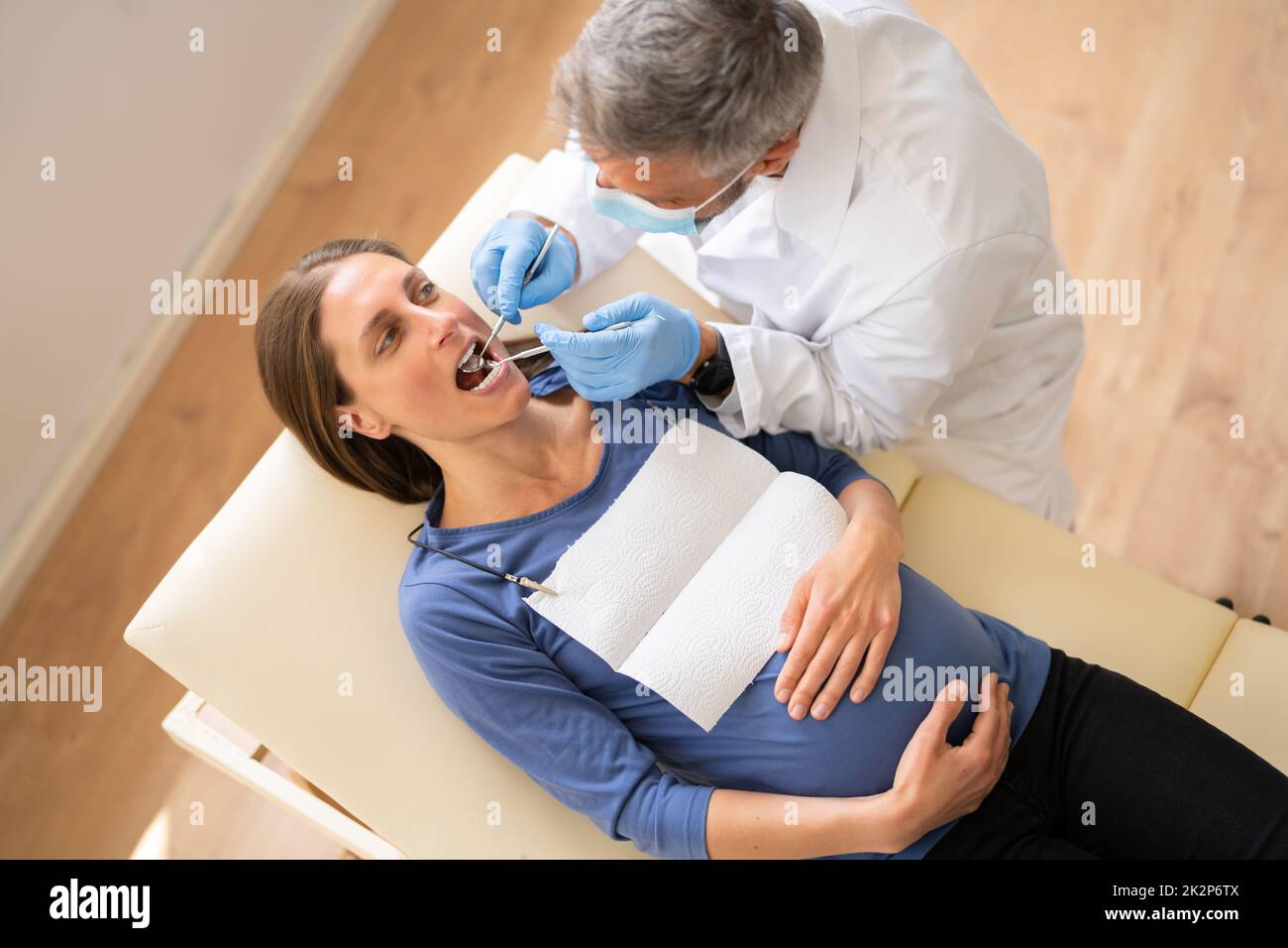 Male Dentist Treating Teeth Of Young Pregnant Woman Stock Photo Alamy