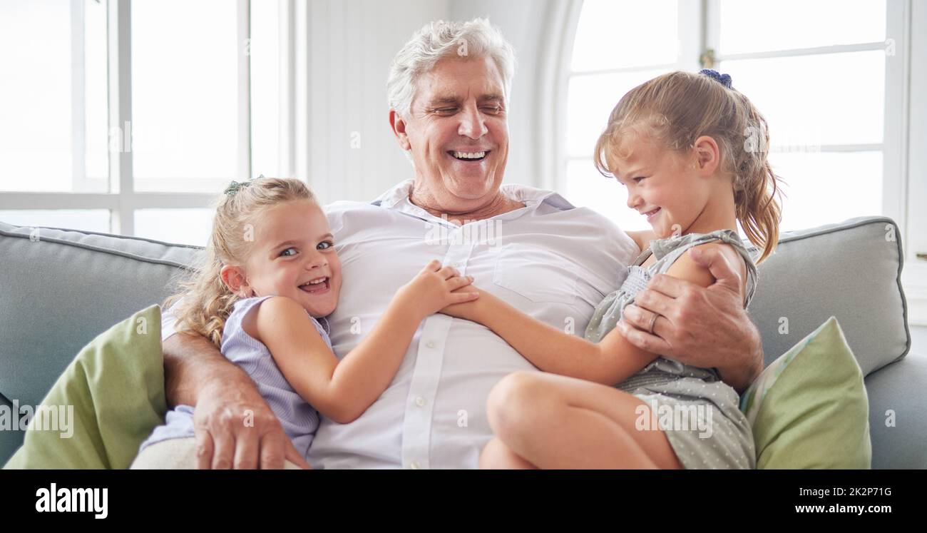 Happy family, retirement and old man playing with children on the sofa bonding, happiness and laughing together. Smile, elderly and grandpa with Stock Photo