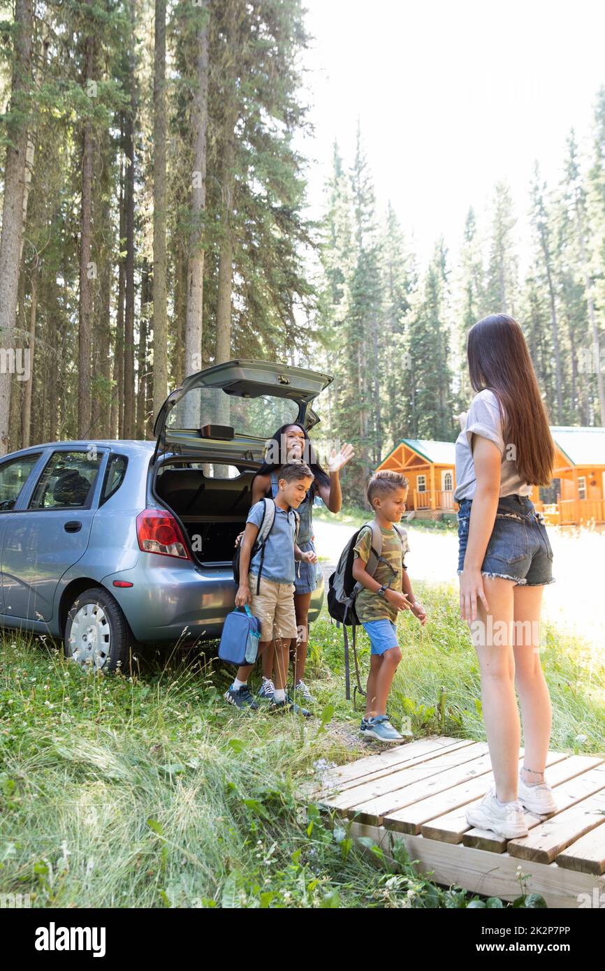 Camp counselor welcoming family to summer camp Stock Photo