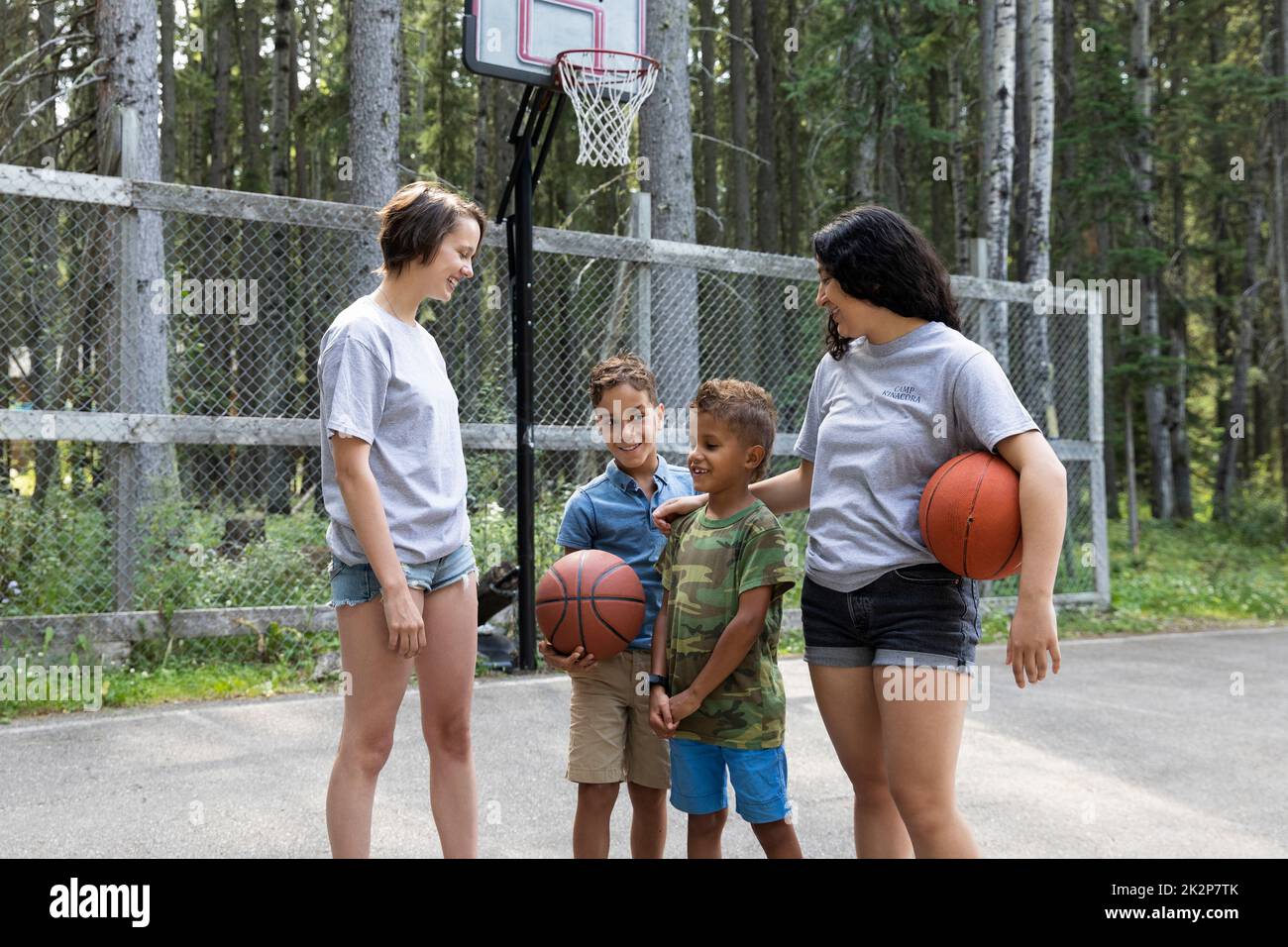 Camp counselors teaching boys basketball at summer camp Stock Photo Alamy