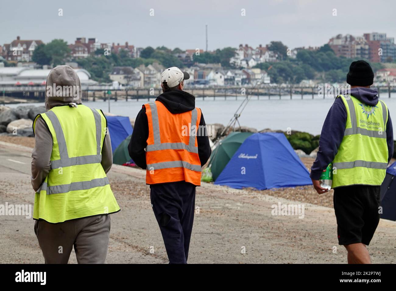 Felixstowe, Suffolk, UK - 23 September 2022 : Three young men in hi viz jackets walking along the seafront. Stock Photo