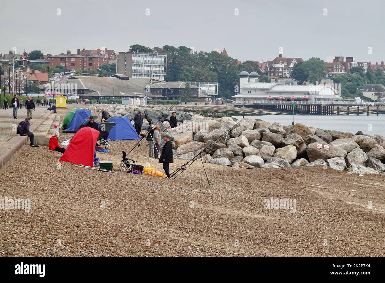 Felixstowe, Suffolk, UK,  23 September 2022 : Fishermen and their tents on the beach. Leisure centre and pier in the distance. Stock Photo