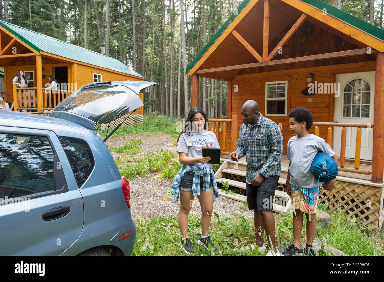 Camp counselor welcoming family to summer camp Stock Photo