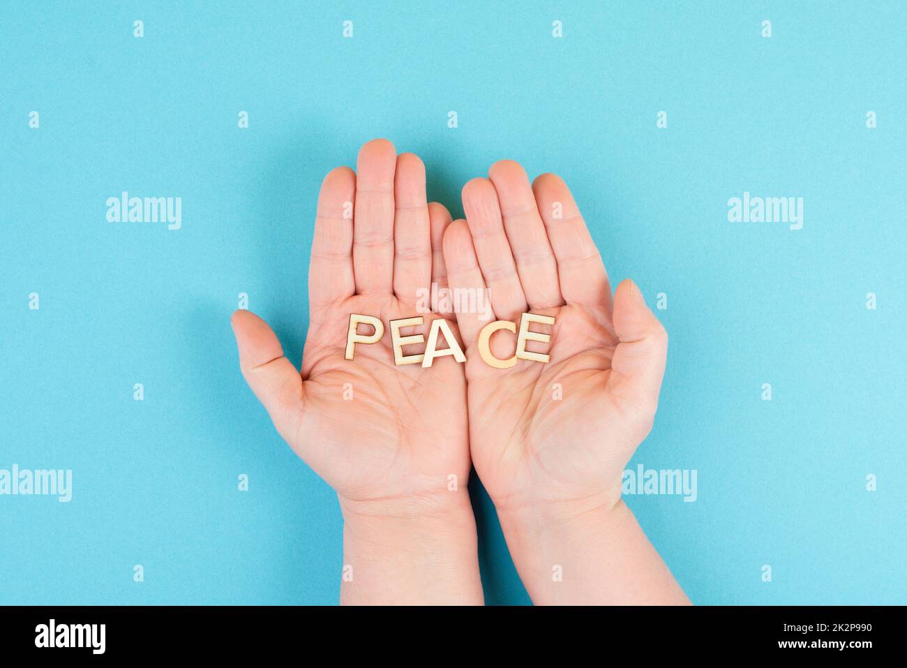 Holding the word peace in the hands, stop war, support Ukraine, living peaceful together Stock Photo