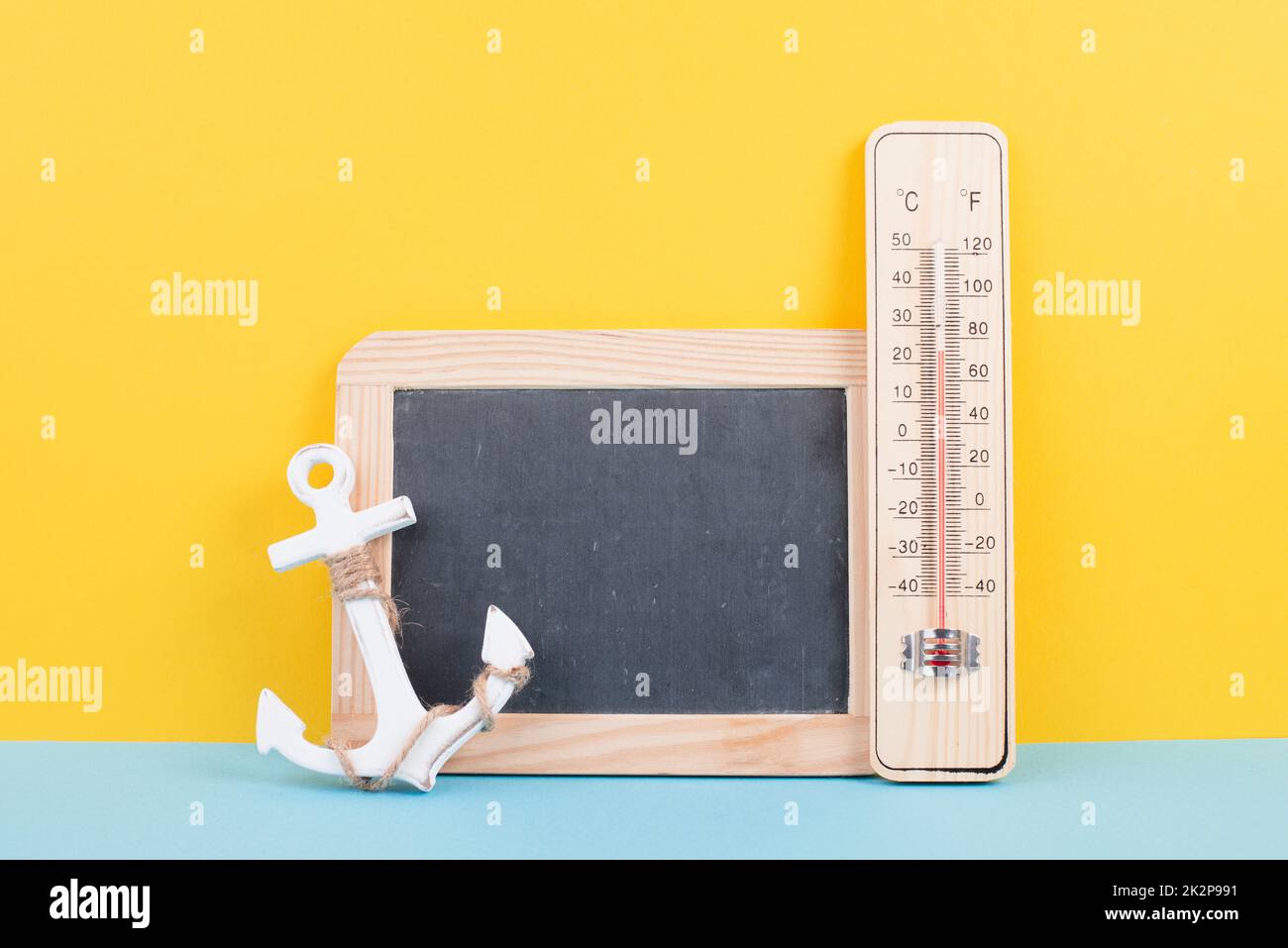 Empty chalkboard with a thermometer and an anchor, holiday background, summer vacation, hot weather, environmental issue Stock Photo