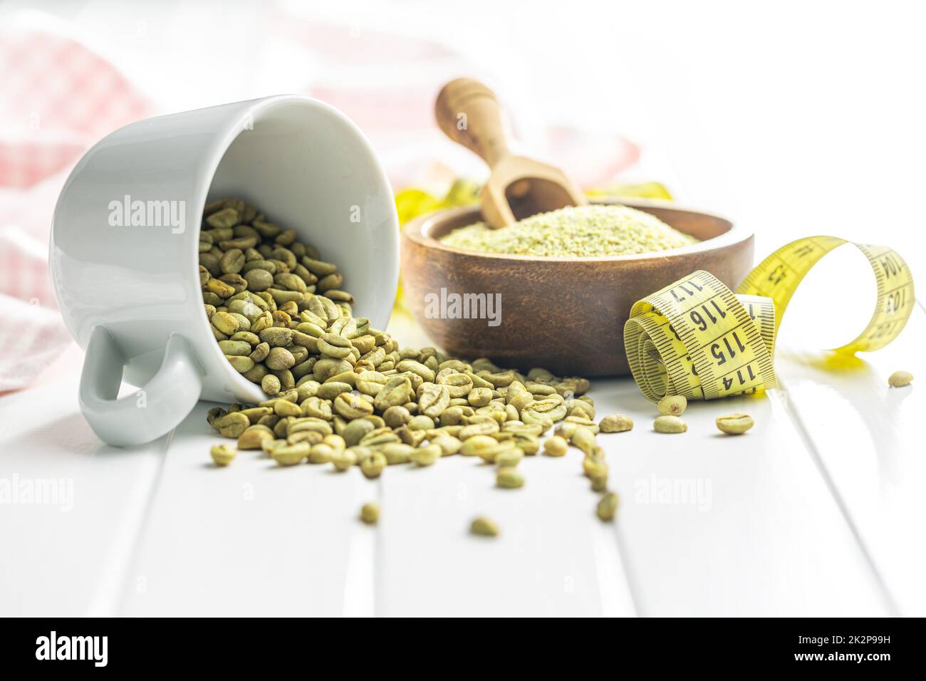 Unroasted green coffee beans on white table. Stock Photo