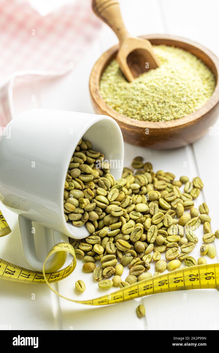 Unroasted green coffee beans on white table. Stock Photo