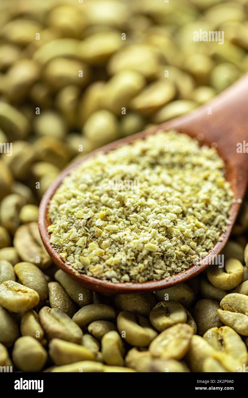Ground green coffee in a scoop and unroasted coffee beans Stock Photo ...