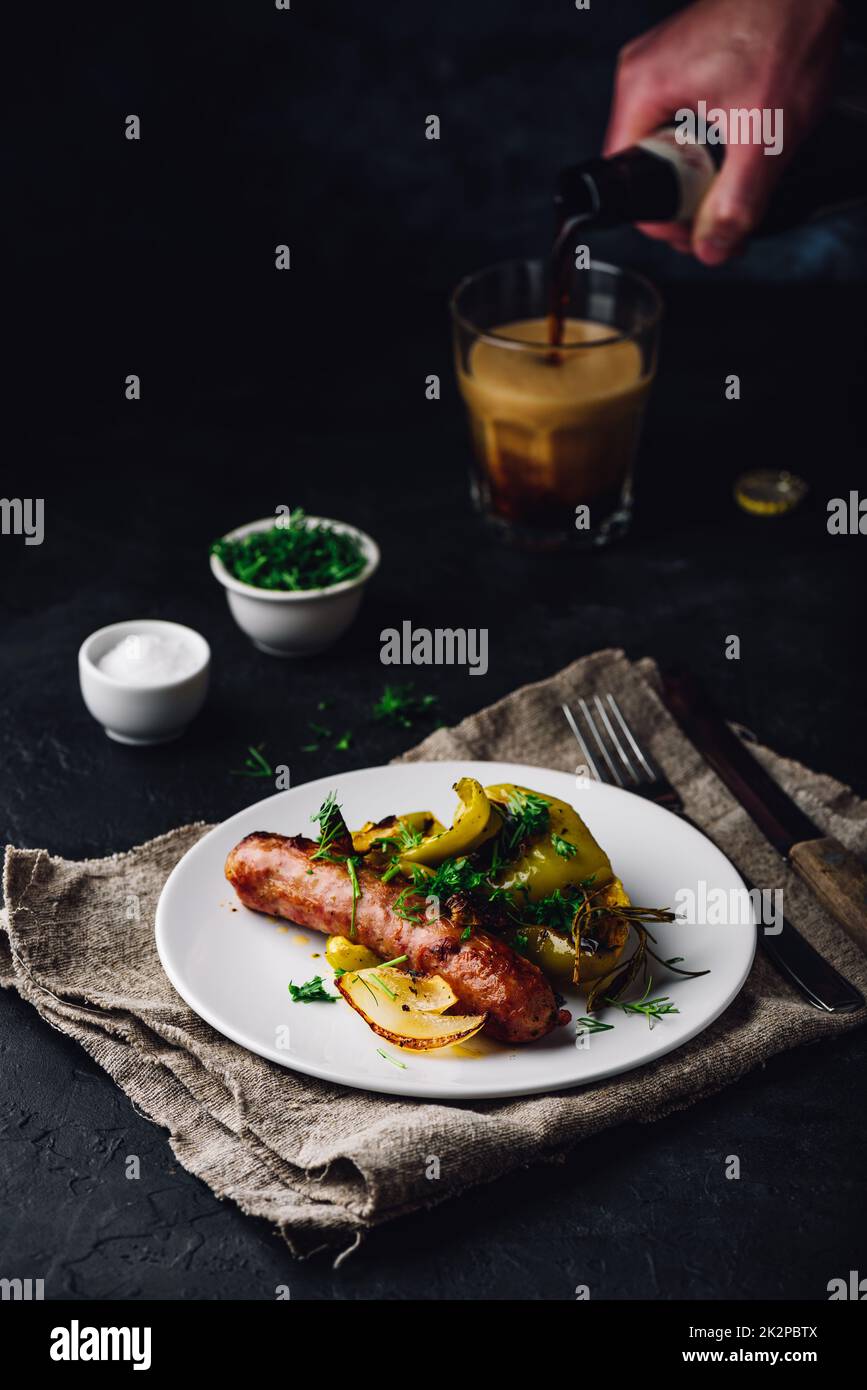 Baked pork sausage with green bell peppers, onion and herbs Stock Photo