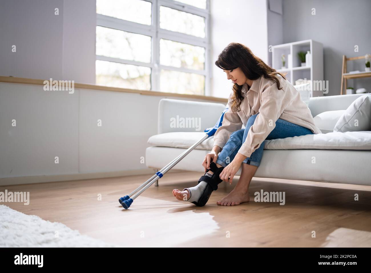 Woman With Leg Injury Using Crutches At Home Stock Photo Alamy