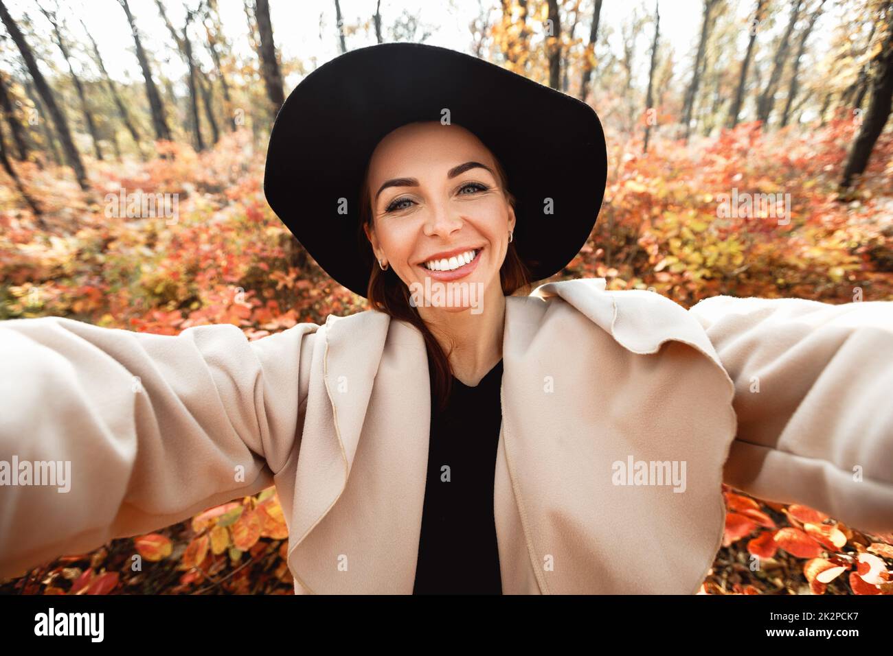happy woman making selfie in the autumn park full of yellow leaves Stock Photo