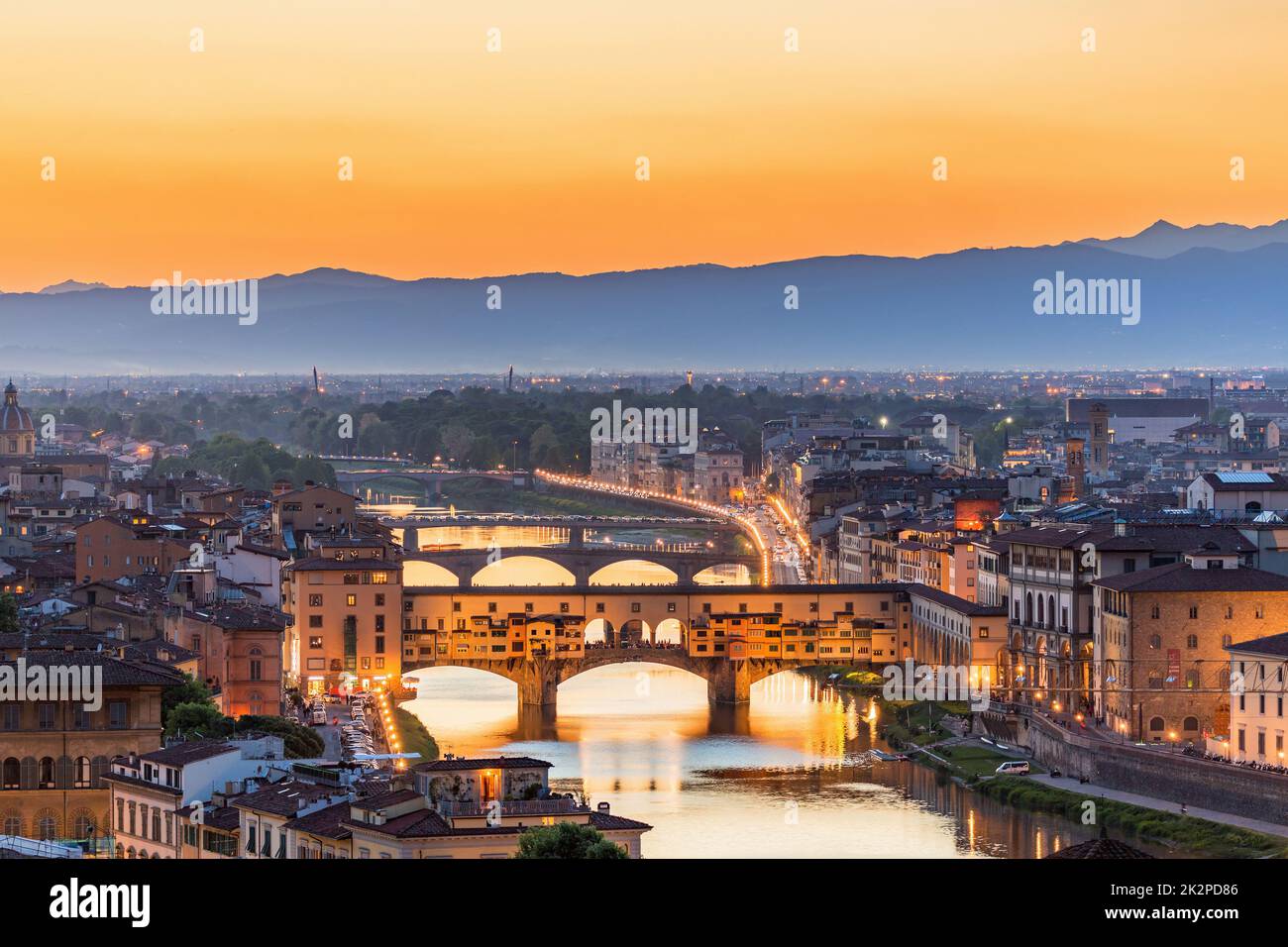 View of Florence at sunset with the Ponte Vecchio bridge over the Arno River Stock Photo