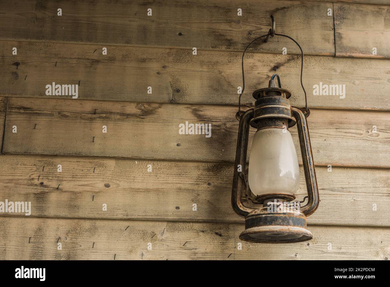 rusty storm lamp hanging on a wooden wall Stock Photo