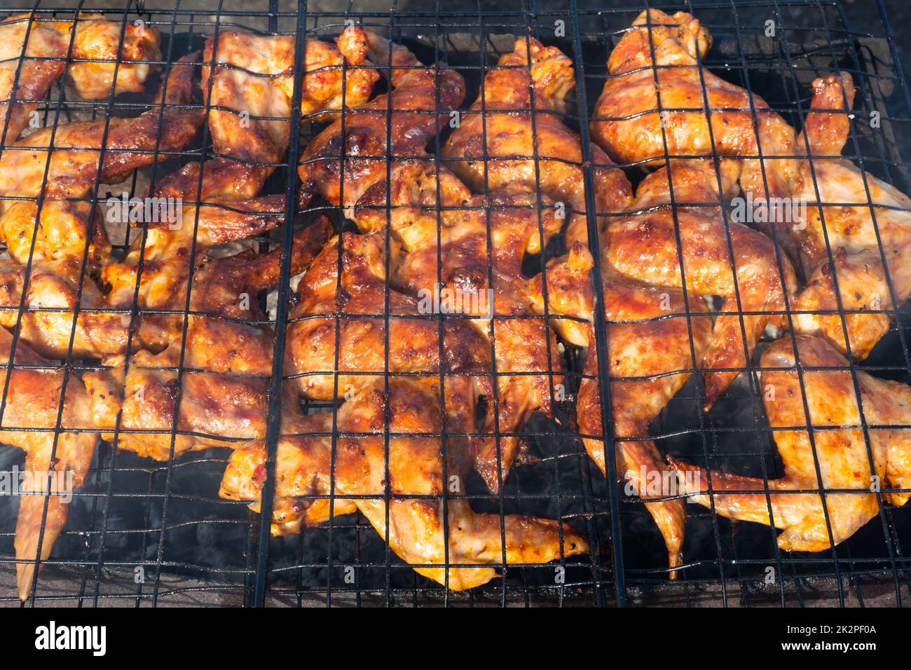 Grilled chicken wings.video 4K cooking fry shish kebab,BBQ, barbecue, shashlik or meat on coals. Cooking meat in the grill on skewers in nature in the summer on a picnic. Pork on the grill Stock Photo