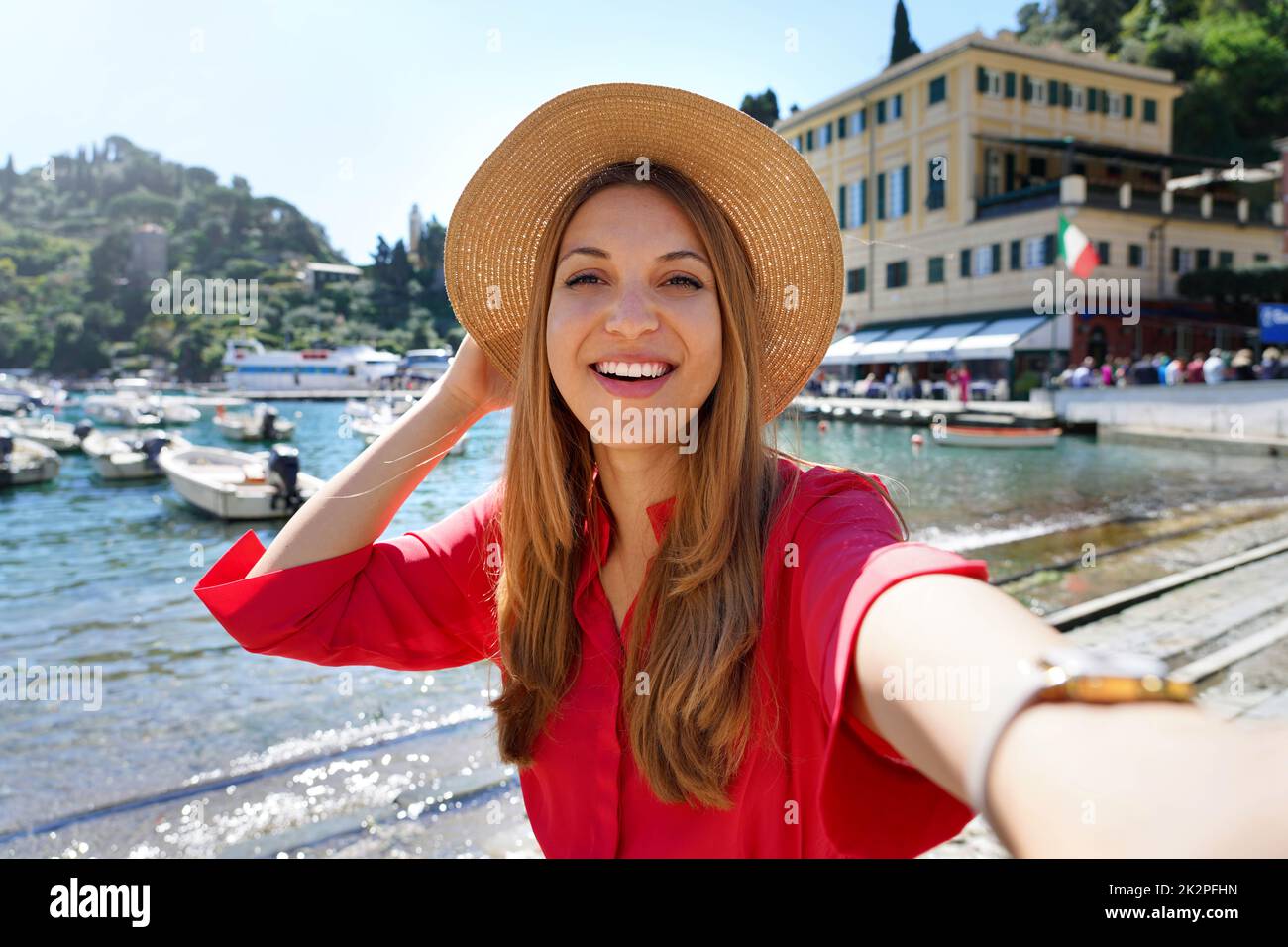Portofino tourist girl taking selfie photo on famous luxury destination. European tourism attraction in Italy. Young woman on vacation. Stock Photo