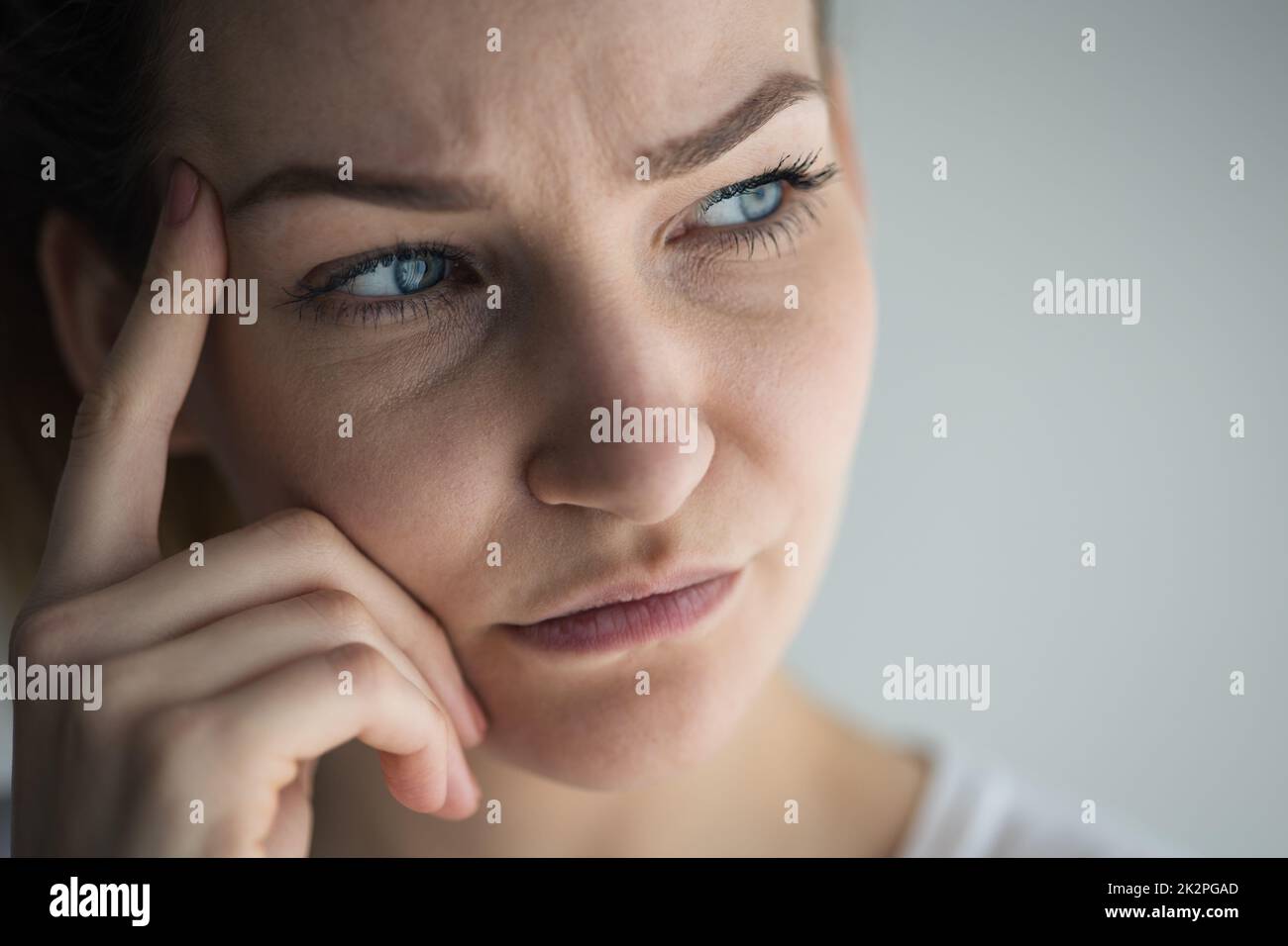 Anxious, worried, stressed young woman looking pensive, pondering, deep in thoughts. Stock Photo