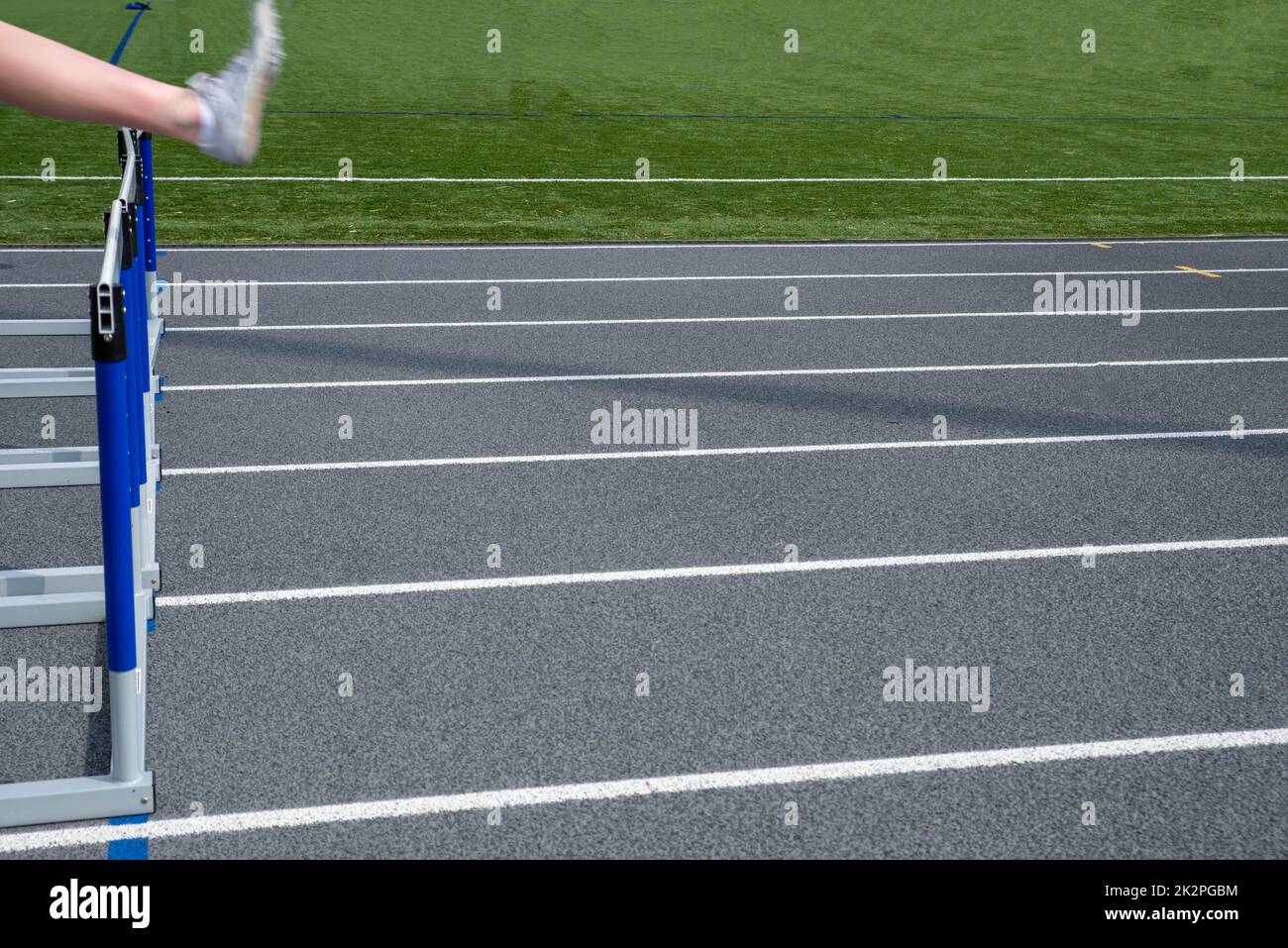 An off center athletic foot leaping over hurdle with copy space Stock Photo