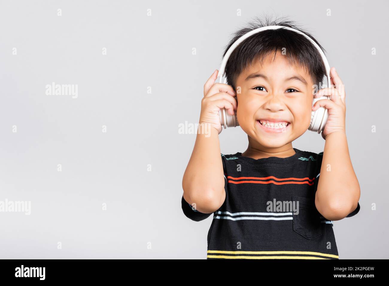 Little cute kid boy 56 years old listen music wear wireless headphones