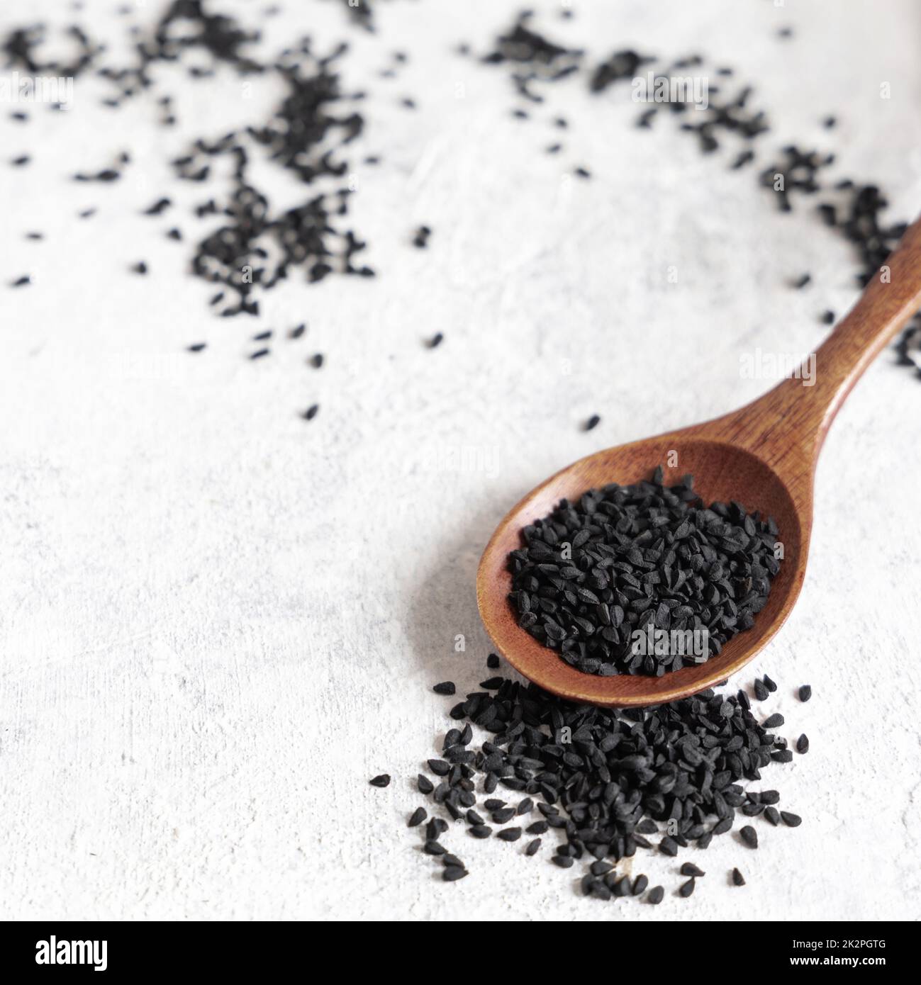 Wooden spoon of Indian spice Black cumin (nigella sativa or kalonji) seeds close up Stock Photo