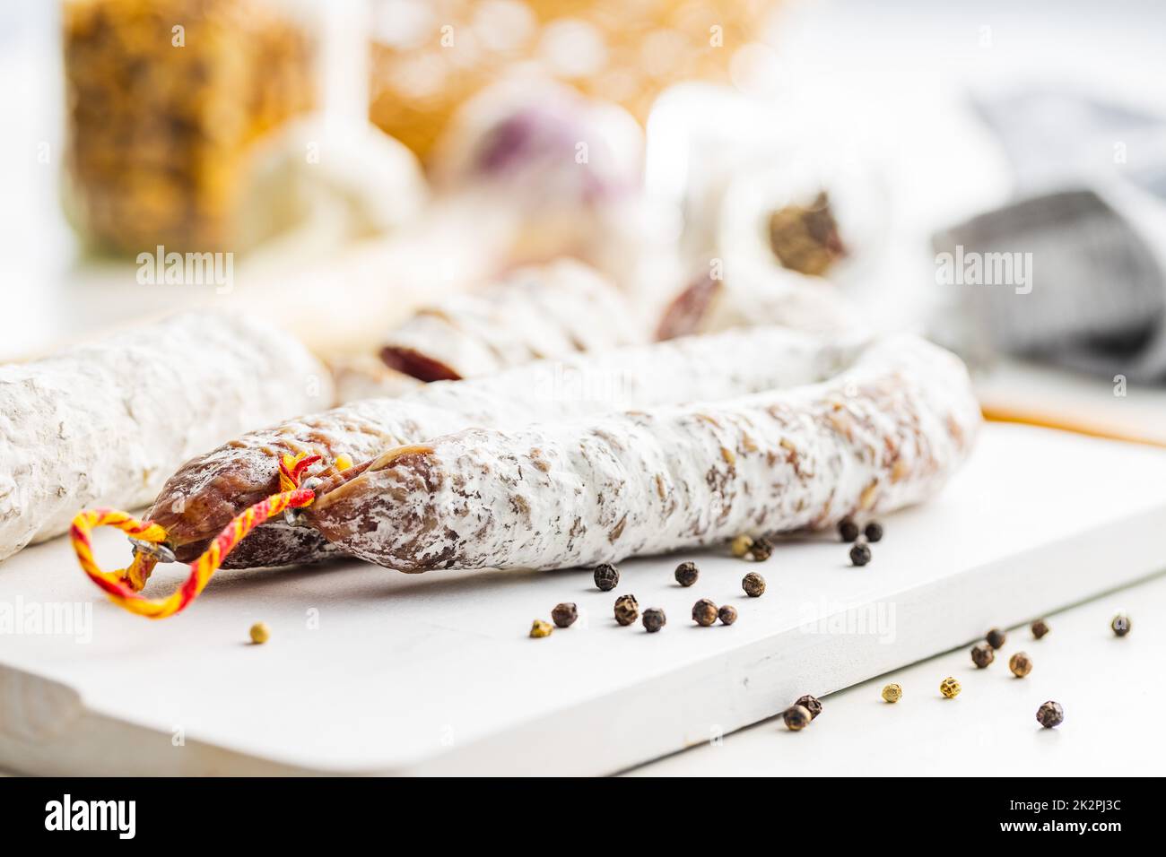 Traditional sausage with white mold. Dried sliced pork salami on cutting board. Stock Photo