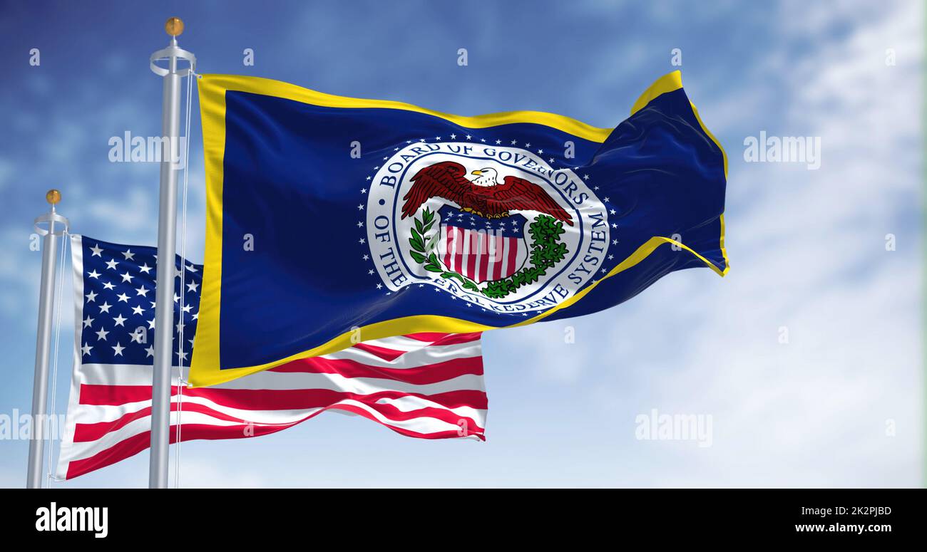 The flag of the American Federal Reserve System waving in the wind with the flag of the United States blurred in the background Stock Photo