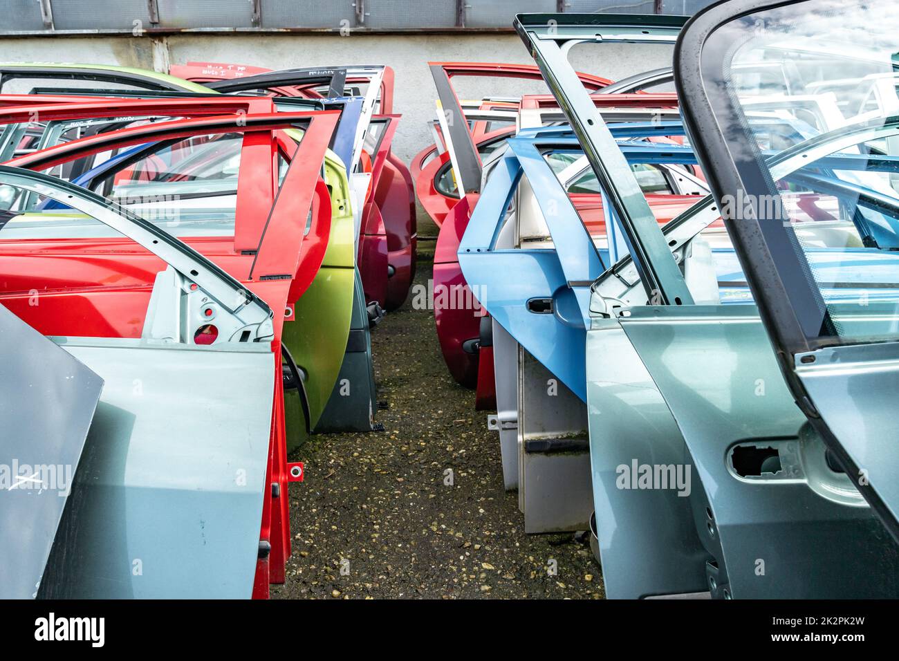different colored car doors at a car junkyard Stock Photo Alamy