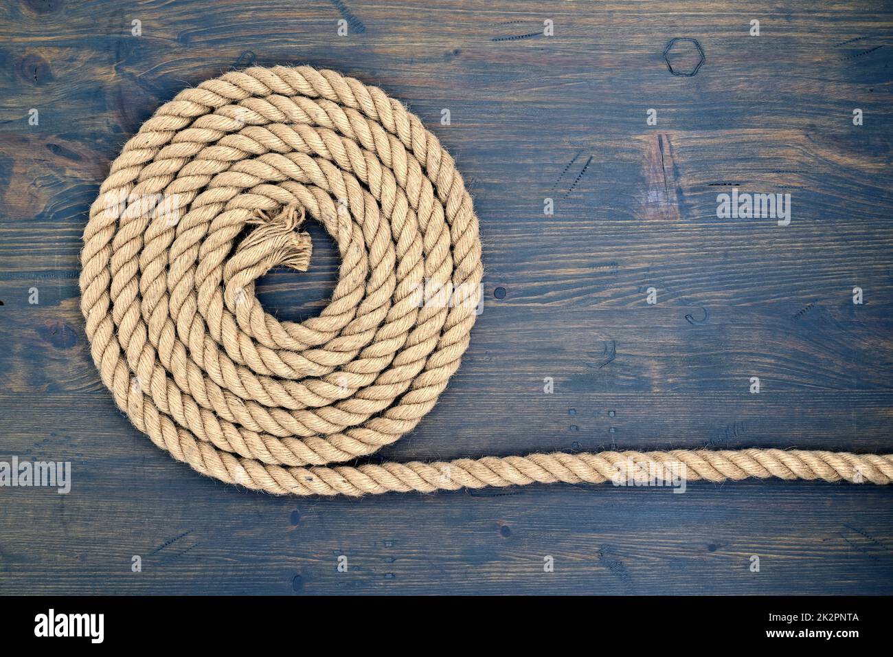 Braided natural jute rope over a rustic wood Stock Photo
