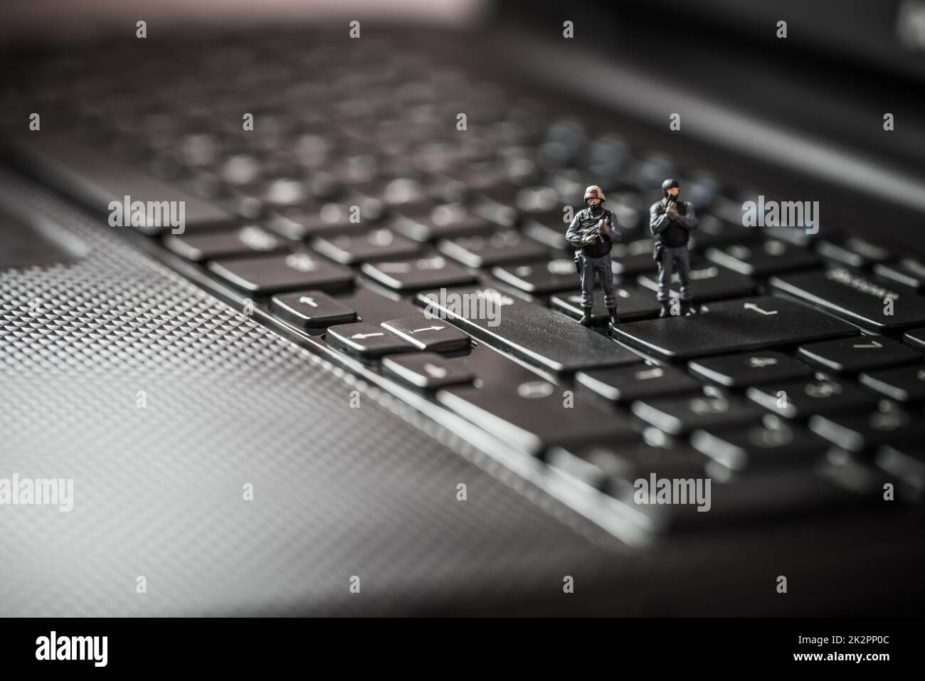 Miniature swat squad protecting laptop computer. Technology concept Stock Photo