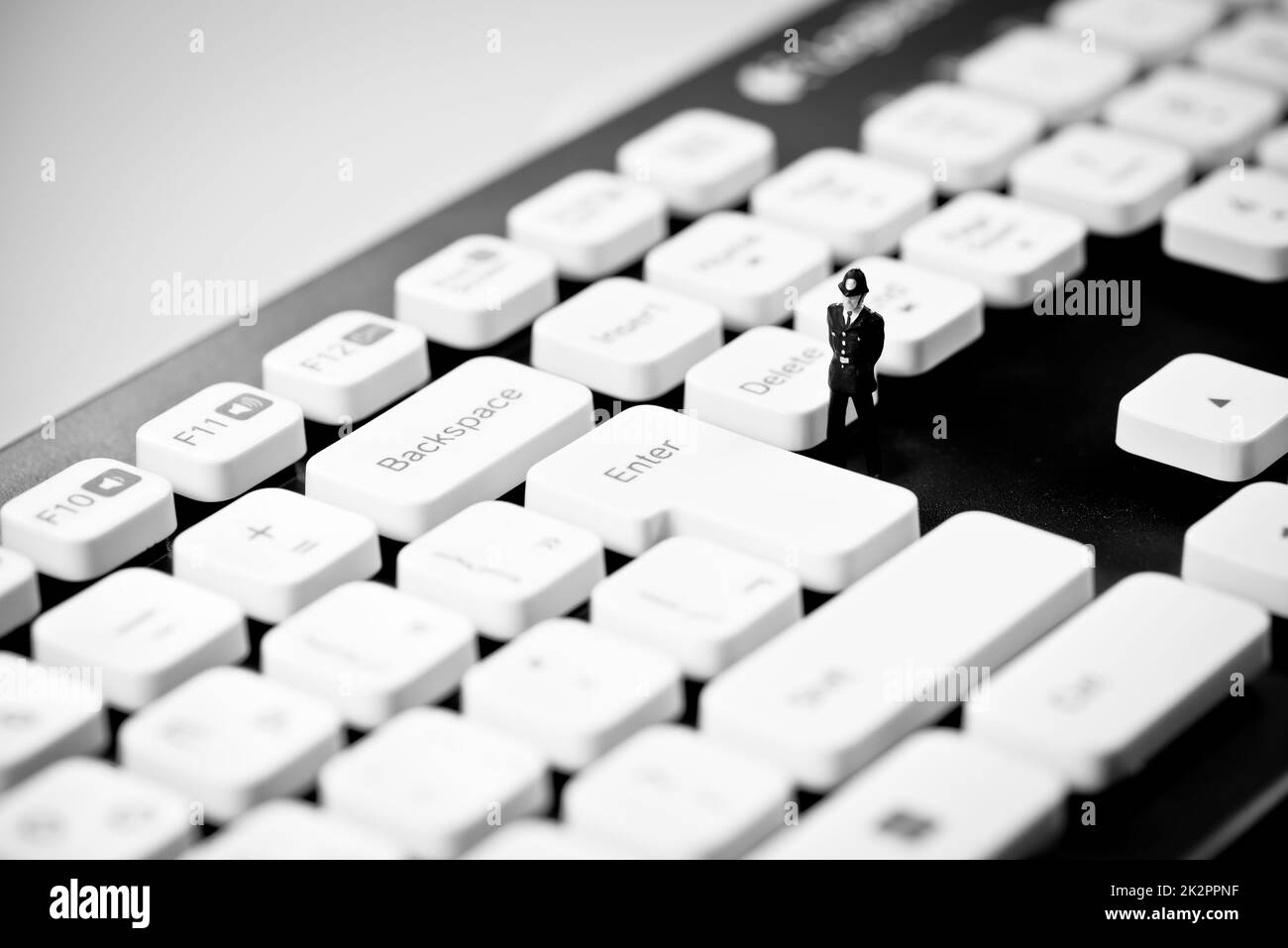 Miniature Police officer on top of computer keyboard. Internet piracy and criminality cpncept Stock Photo
