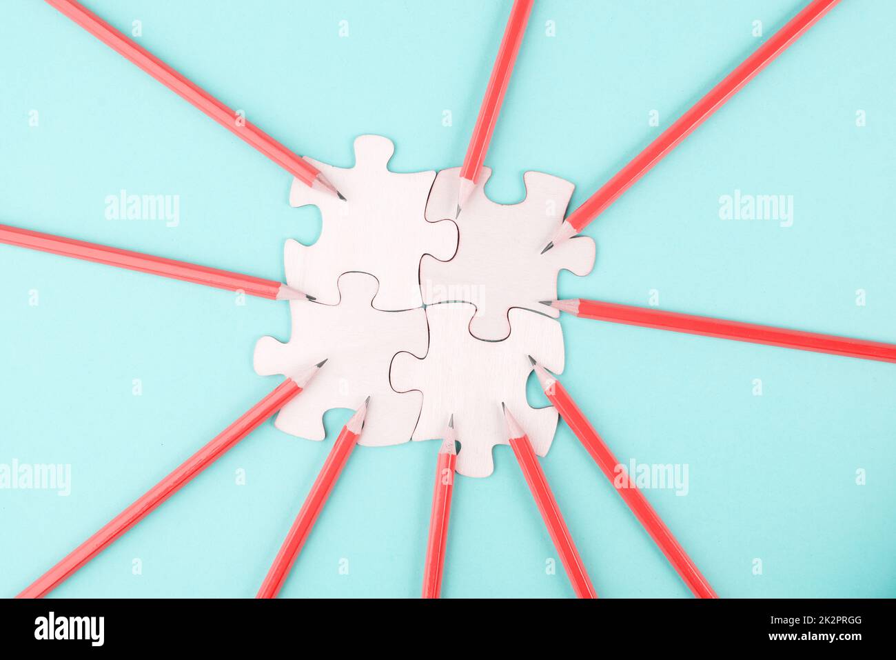 Working as a team, puzzle pieces connect together, pencils point to the jigsaw, brainstorming for ideas, business and education concept Stock Photo