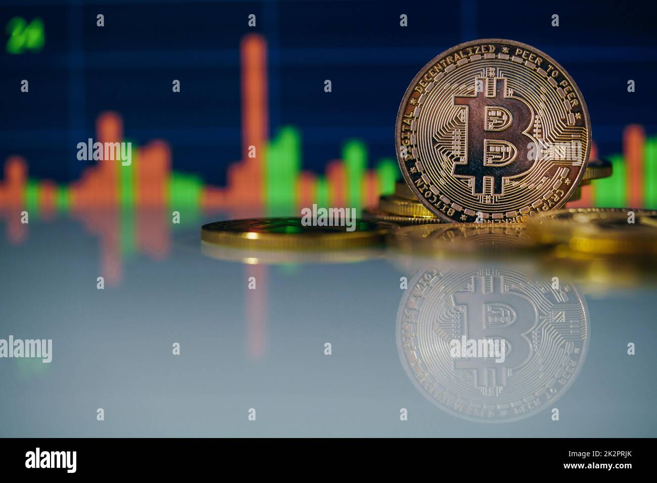 Stack or heap of gold Bitcoins cryptocurrency coins with candle stick graph chart and digital background. Stock Photo