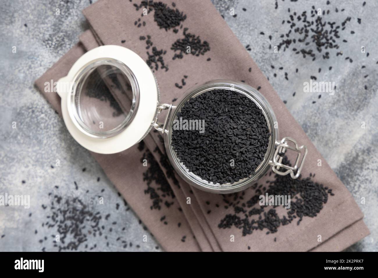Indian spice Black cumin (nigella sativa or kalonji) seeds in glass jar top view Stock Photo