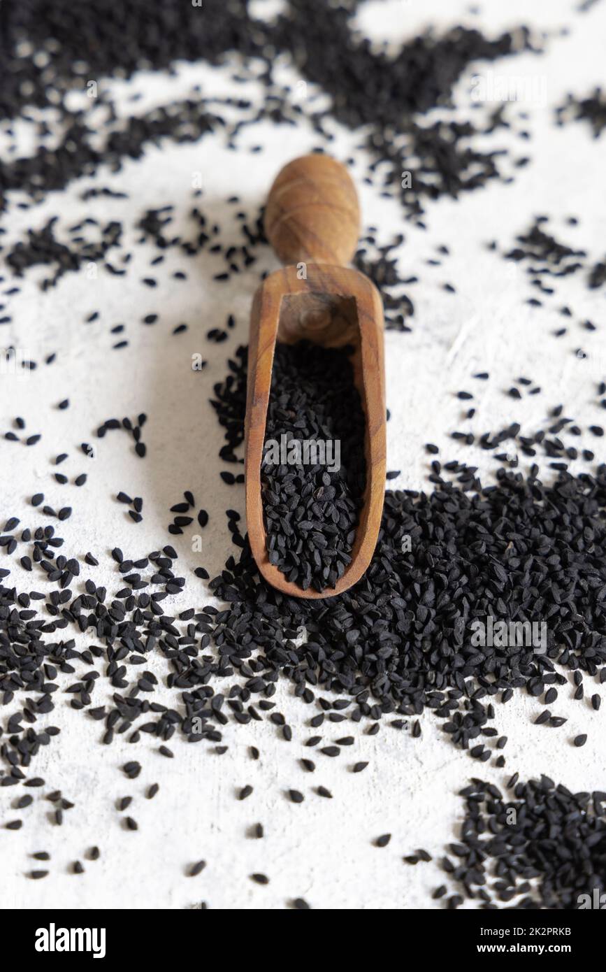 Wooden scoop of Indian spice Black cumin (nigella sativa or kalonji) seeds close up Stock Photo