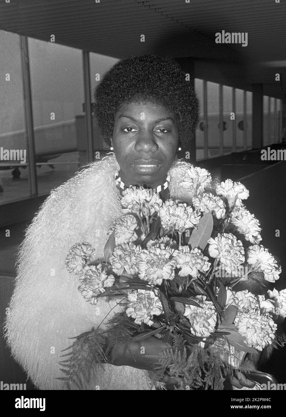 Nina Simone at Schiphol airport carrying a bouquet of flowers photographed by Jack de Nijs for Anefo - 1969 Stock Photo