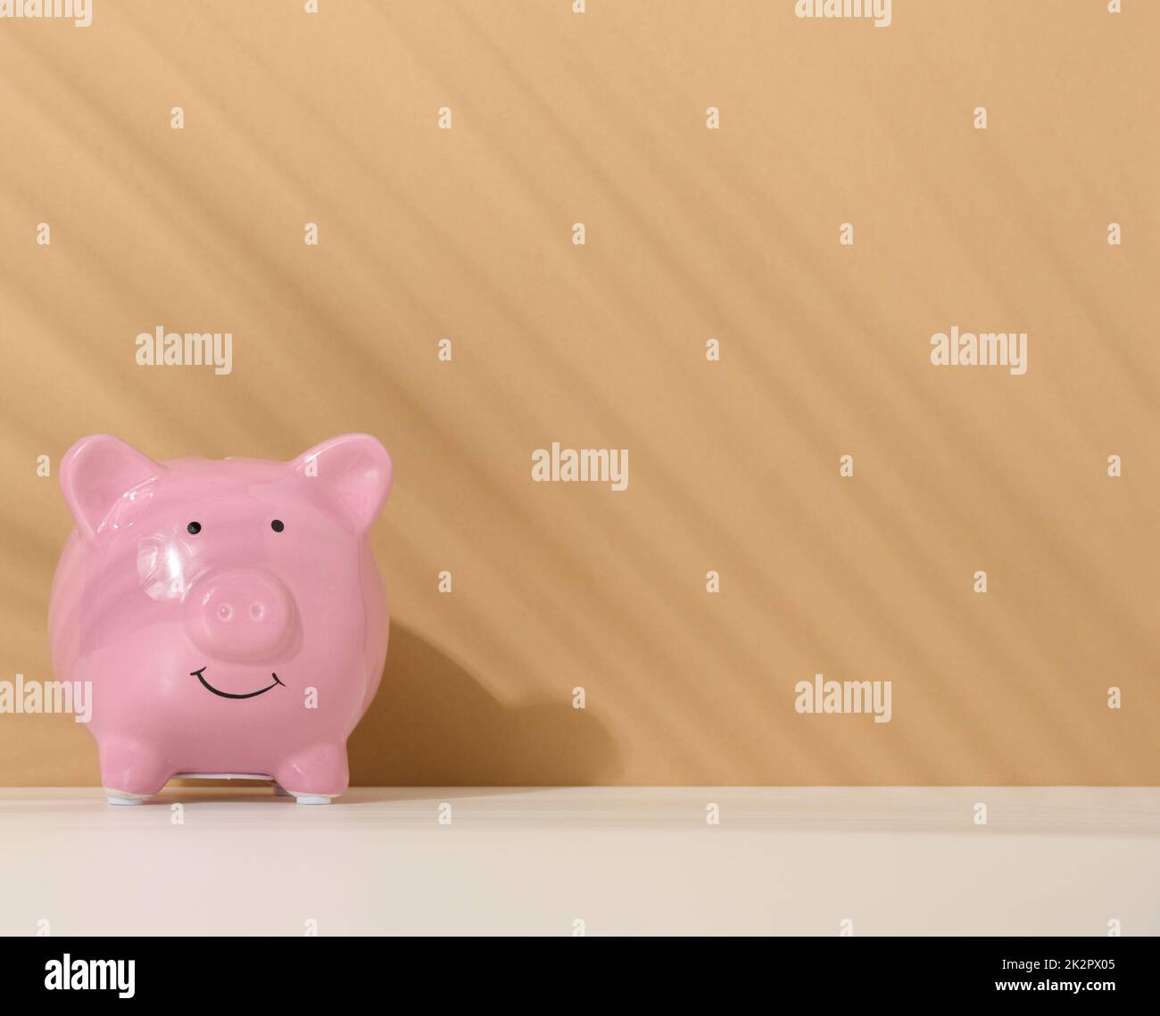 ceramic pink piggy bank on a brown background. Concept of increasing income from bank accounts, savings Stock Photo