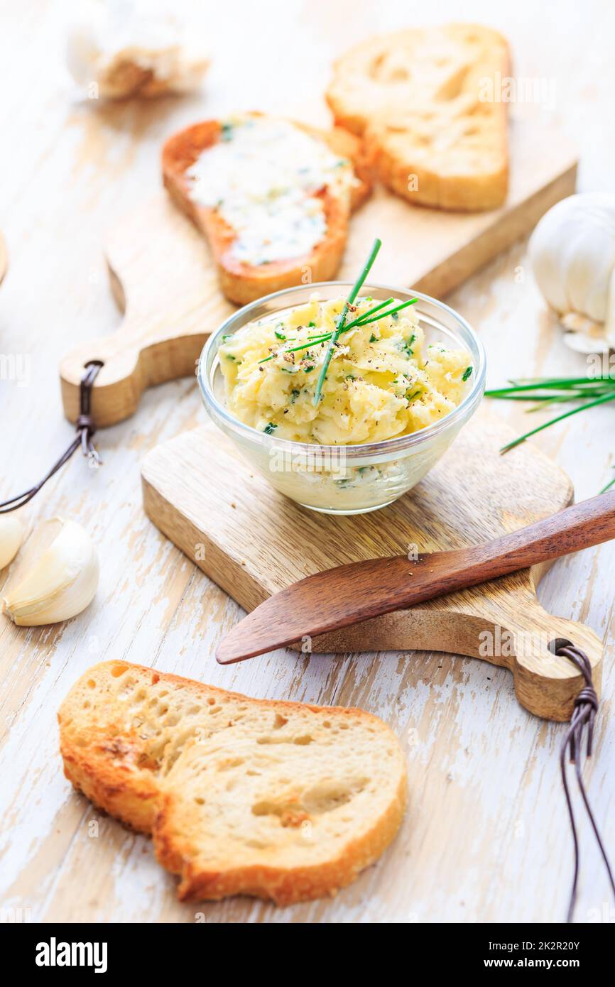 Homemade garlic butter with herbs and chives and fresh roasted baguette