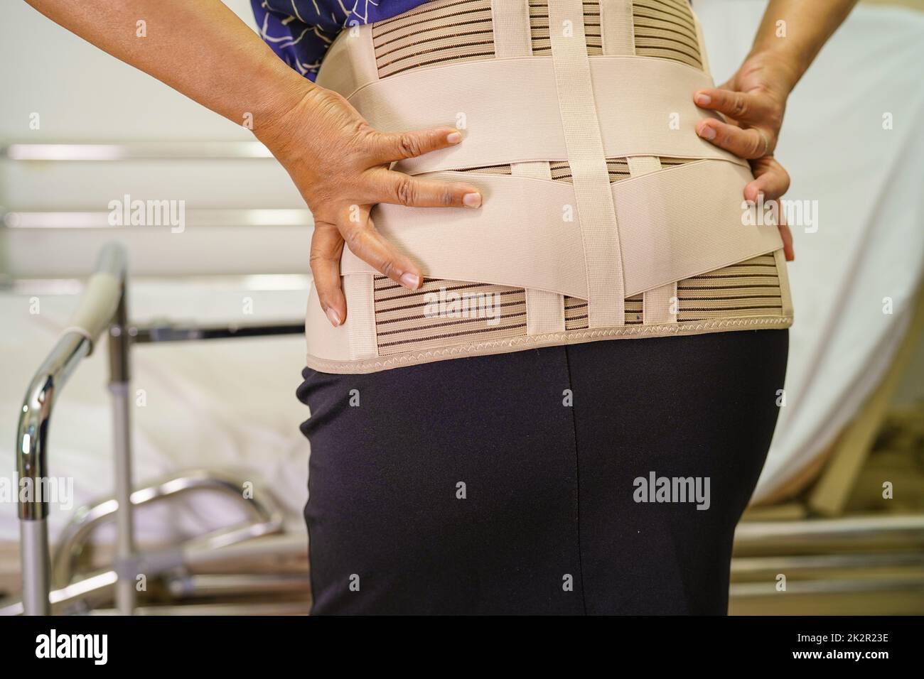 Asian lady patient wearing back pain support belt for orthopedic lumbar