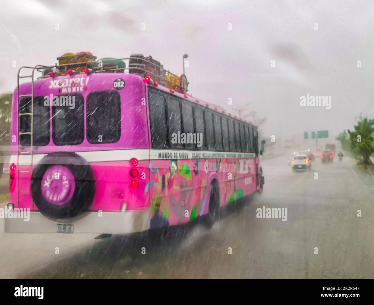 Pink Xcaret bus drives in heavy rain on highway Mexico Stock Photo Alamy