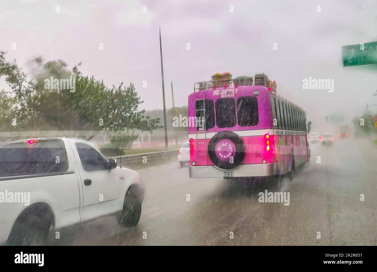 Pink Xcaret bus drives in heavy rain on highway Mexico Stock Photo Alamy