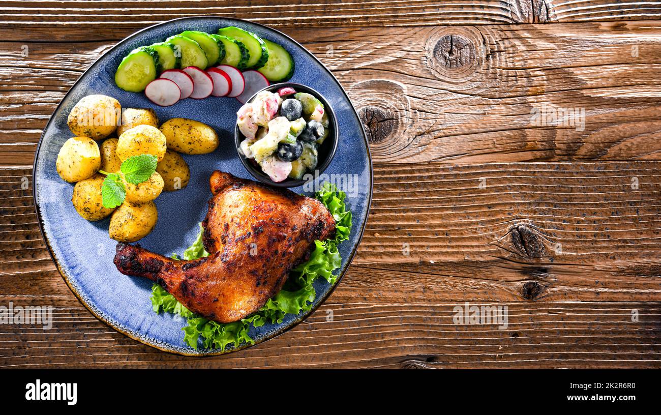 Baked chicken leg with potatoes and vegetable salads Stock Photo Alamy