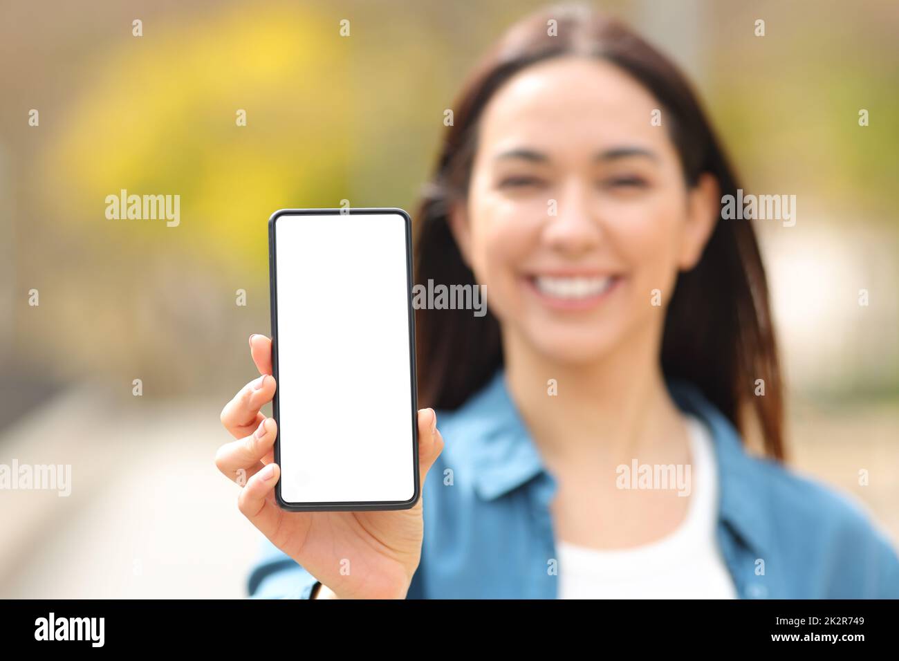 Happy woman showing smart phone screen at camera Stock Photo - Alamy