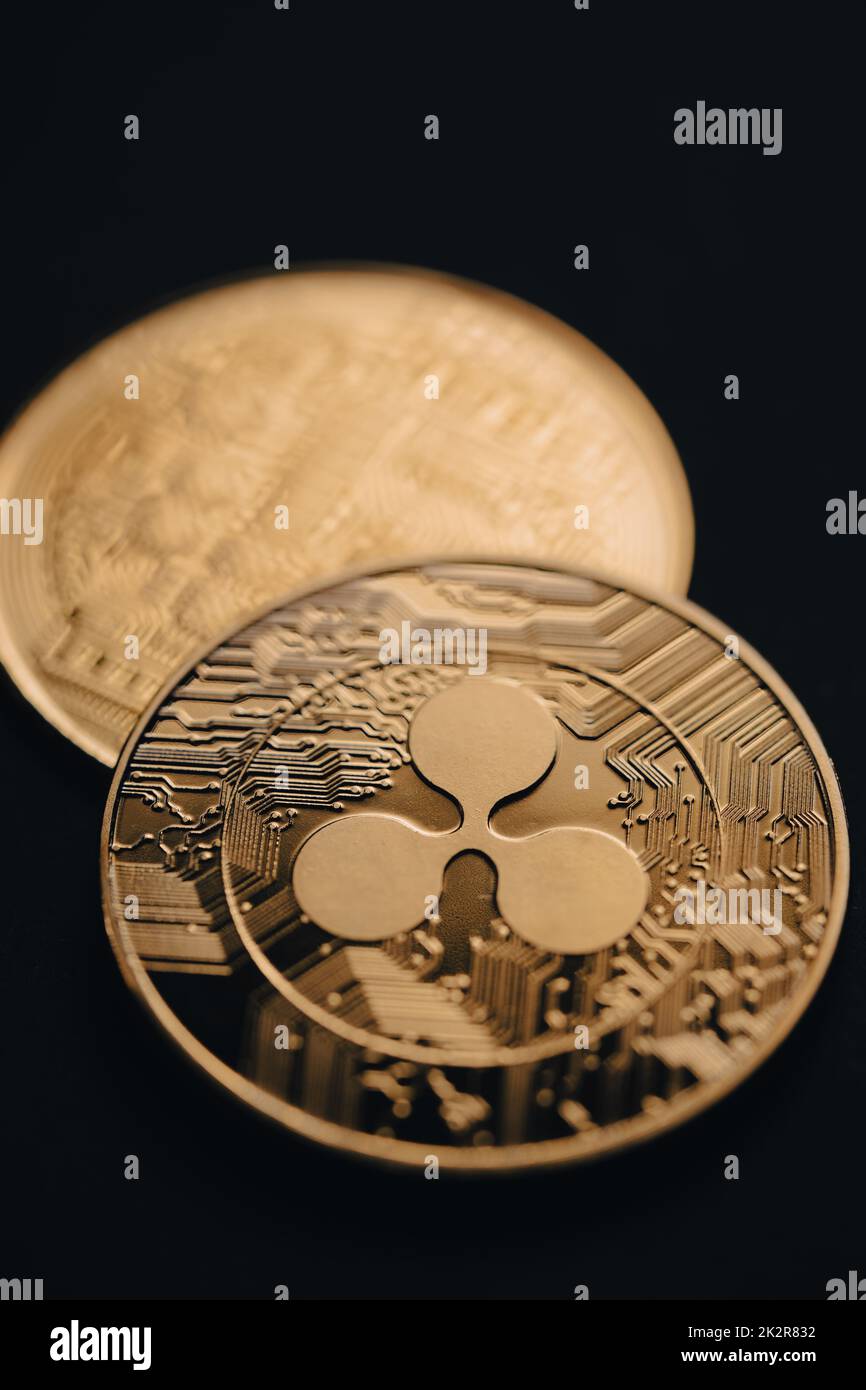 Close up shot of a golden Ripple XRP digital cryptocurrency, front and back. Stock Photo